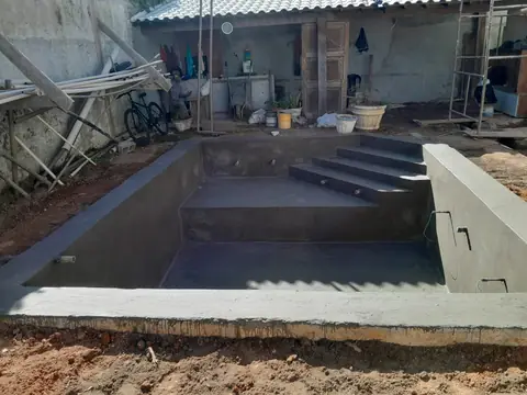 Piscina em construção, com a estrutura de concreto e a escada prontas